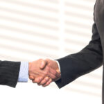 Male and female caucasian models shaking theor hands on bright b