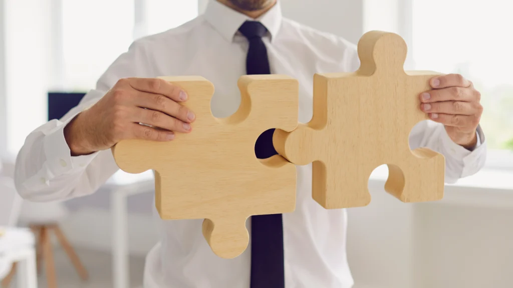 Joven-empresario-uniendo-engranes